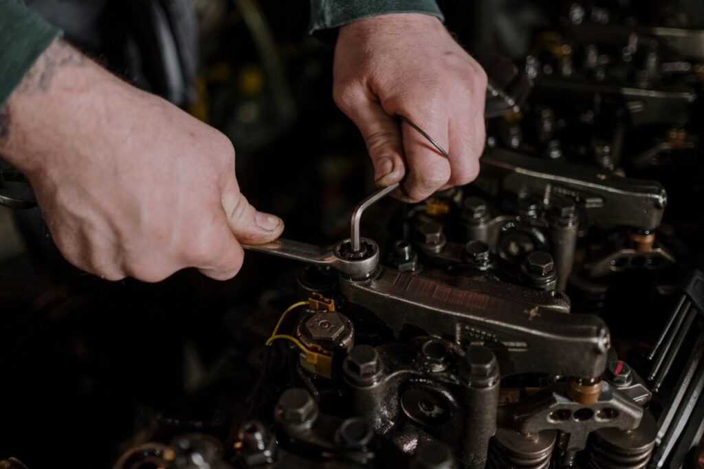 pexels-photo-7564865-7564865 Close-up of a mechanic using a wrench and Allen key to fix an engine.